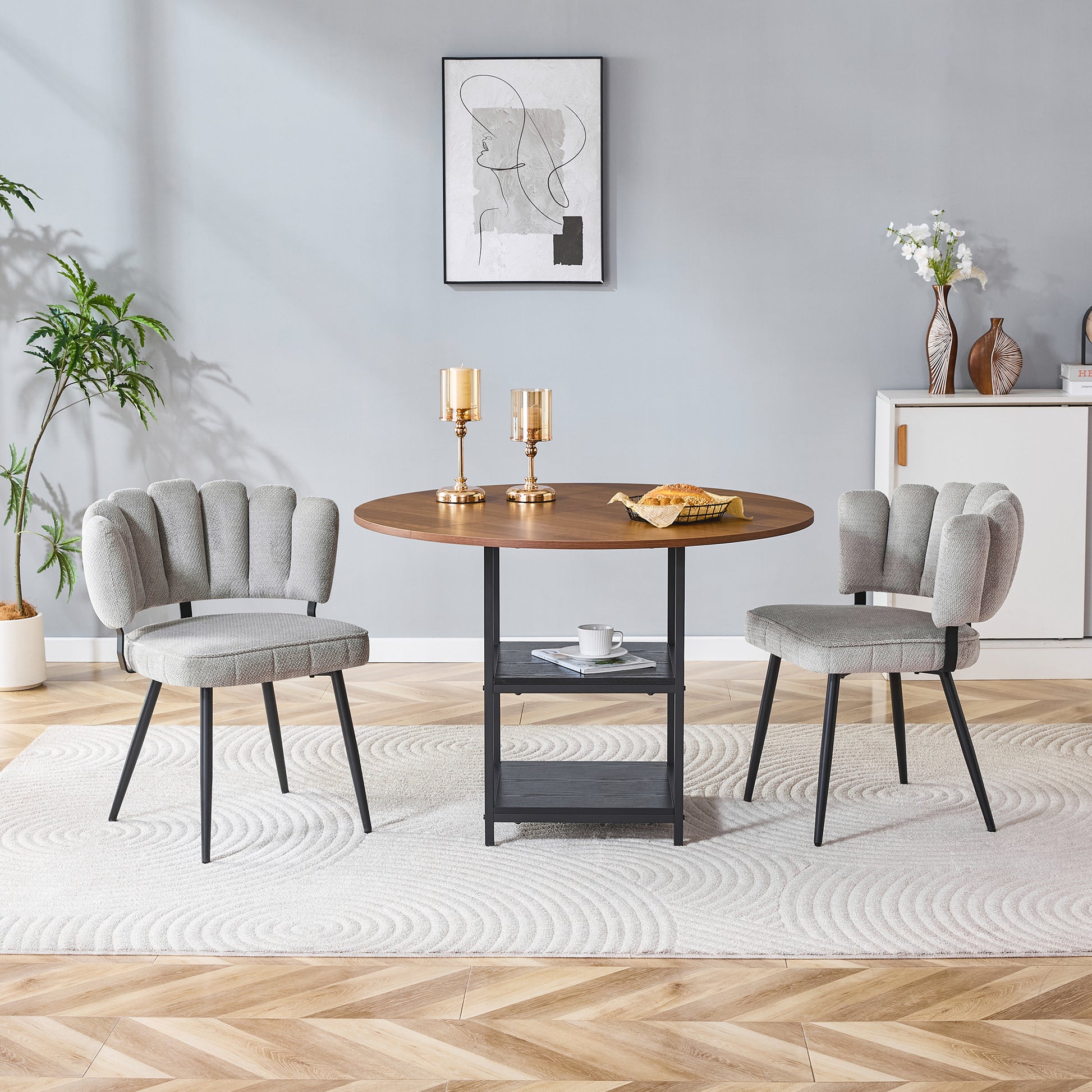 Gigab2b original image - Tisch- und Stuhlset. Runder 107 cm Esstisch in Nussbaum-Optik mit doppelter Stauraum-Ebene + 2 graue Stoff-Esszimmerstühle mit strukturierter blütenförmiger Rückenlehne – ideal für kleine Wohnungen.