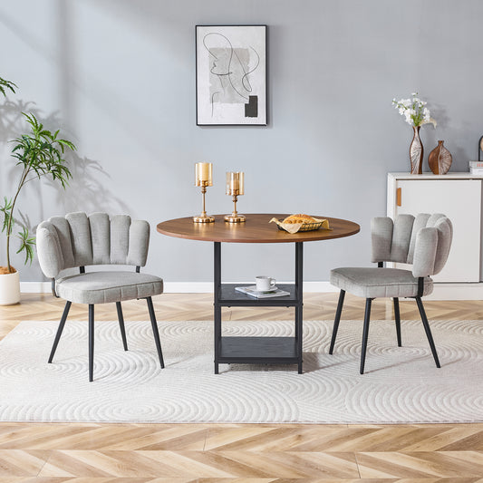 Gigab2b original image - Tisch- und Stuhlset. Runder 107 cm Esstisch in Nussbaum-Optik mit doppelter Stauraum-Ebene + 2 graue Stoff-Esszimmerstühle mit strukturierter blütenförmiger Rückenlehne – ideal für kleine Wohnungen.