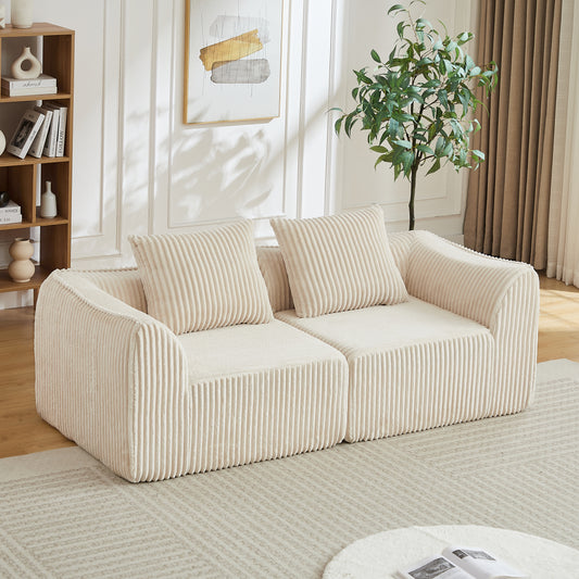 Gigab2b original image - Minimalistisches Cordsofa mit geschwungenen Linien und einer sanft abfallenden Rückenlehne, komplett mit zwei Kissen.