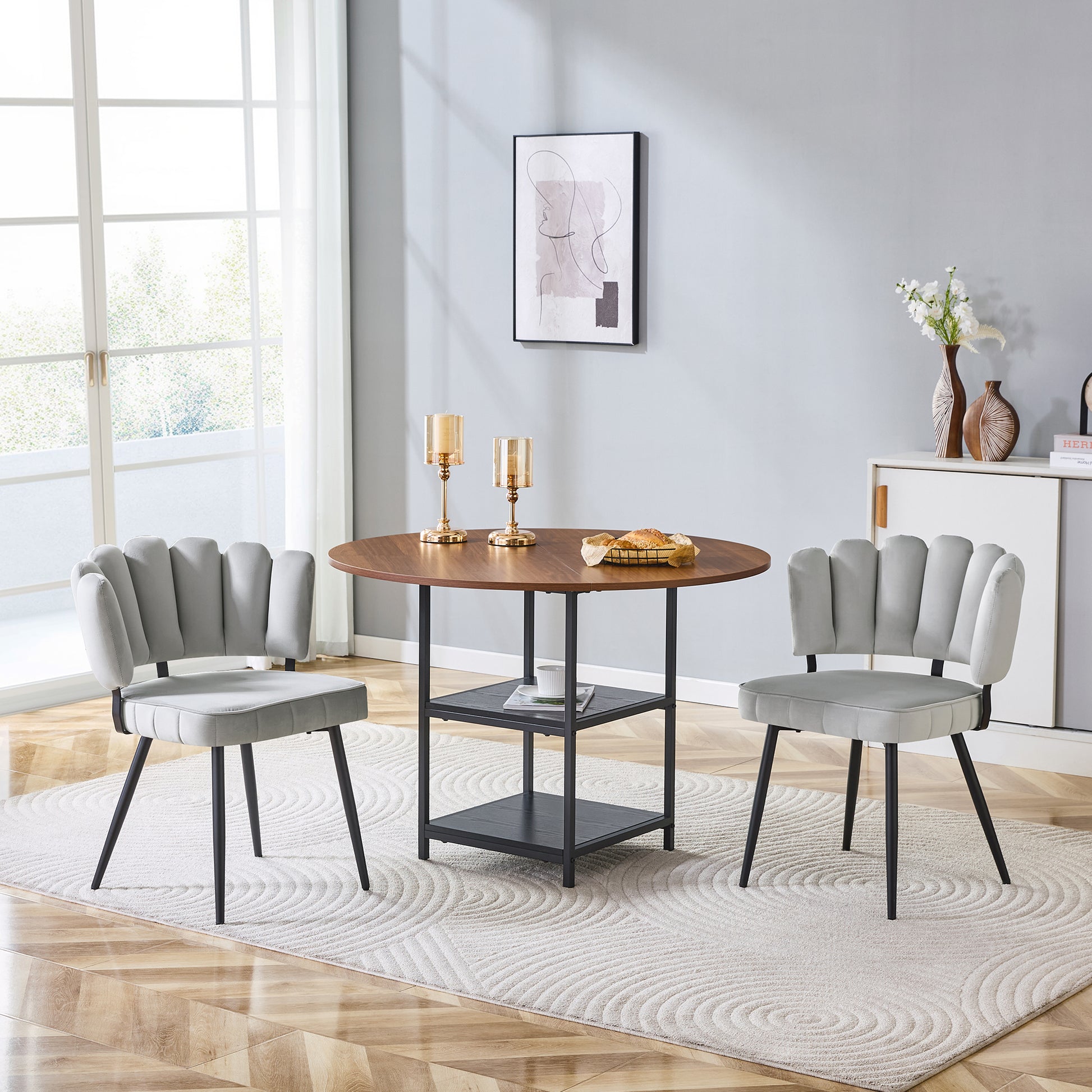 Gigab2b original image - Tisch- und Stuhlset. Runder 107 cm Esstisch in Nussbaum-Optik mit doppelter Stauraum-Ebene + 2 hellgraue Stoff-Esszimmerstühle mit blütenförmiger Rückenlehne – ideal für kleine Wohnungen.